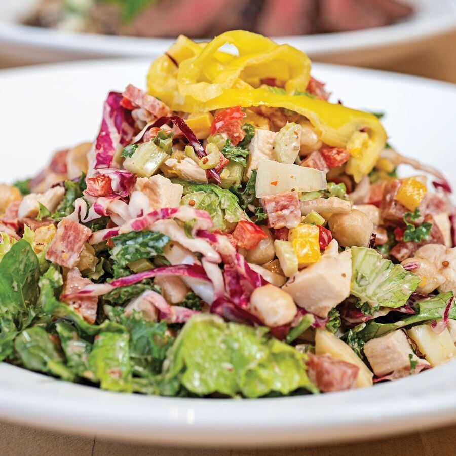 Chop Chop salad with romaine, arugula, a touch of radicchio and kale, with diced celery, cauliflower, bell peppers, tomatoes, chickpeas, salami, herb roasted chicken, provolone and pickled banana peppers