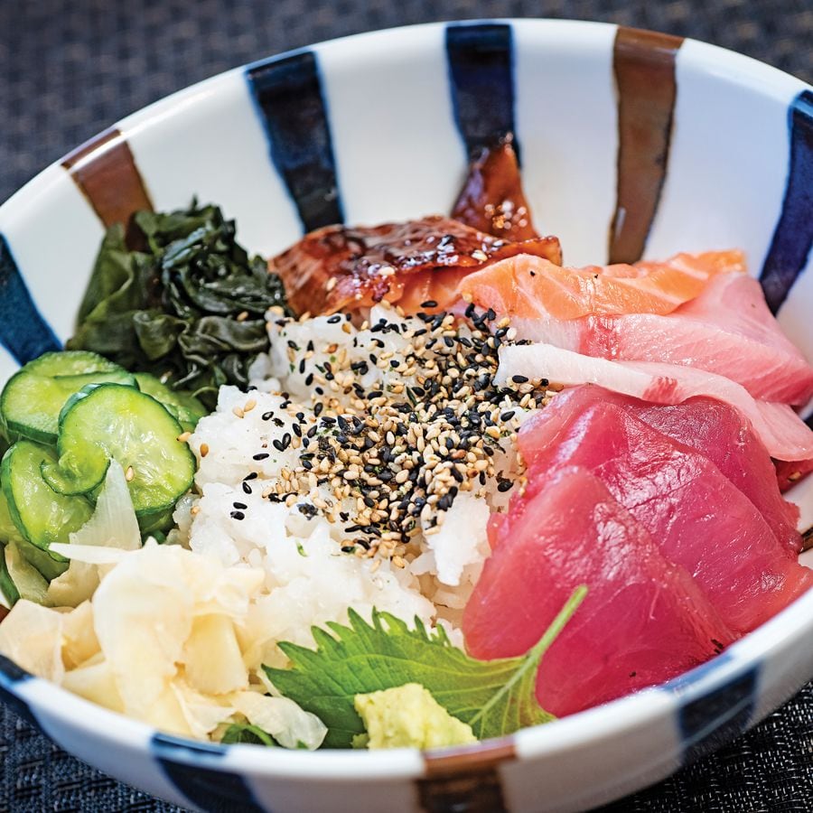 Chirashizushi of the Day with sashimi in the form of a Japanese rice bowl, vegetables, wakame, and fresh wasabi root