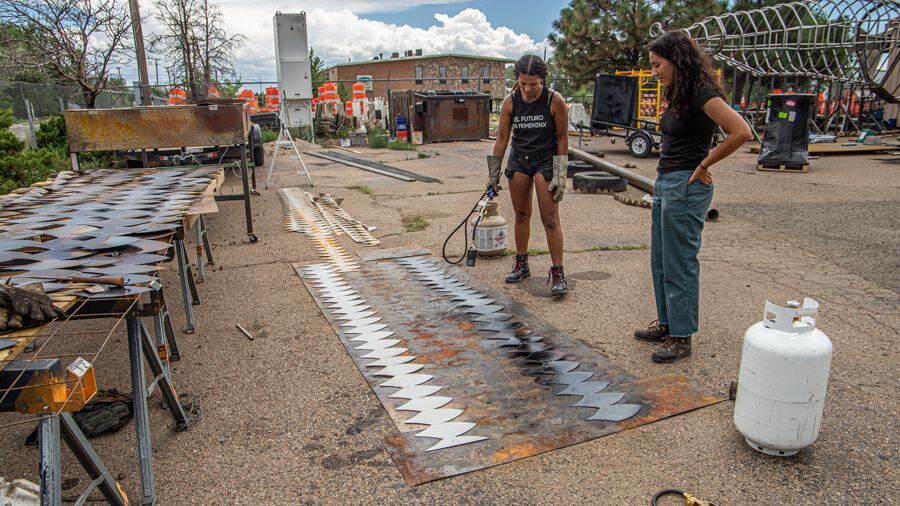 Artist and RIDE Lead Nikesha Breeze and project intern Sophia Paez create a faux patina on steel with a blowtorch.